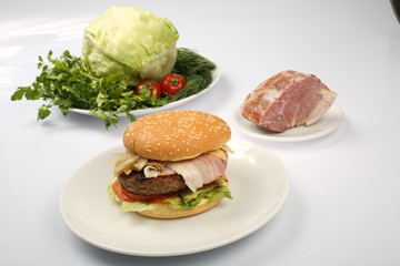 cheeseburger, chicken cutlet, bacon, tomatoes and slices of cheese, dressed with sauce and green salad for a restaurant menu on a white isolated background
