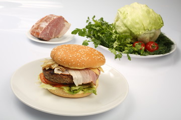 cheeseburger, chicken cutlet, bacon, tomatoes and slices of cheese, dressed with sauce and green salad for a restaurant menu on a white isolated background