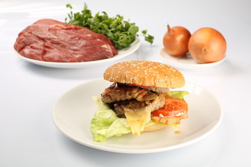 cheeseburger, chicken cutlet, bacon, tomatoes and slices of cheese, dressed with sauce and green salad for a restaurant menu on a white isolated background
