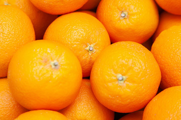 Many tasty ripe orange mandarins are piled on counter at the farmers market. New Year fruit concept, fresh squeezed vitamin juice, healthy foods