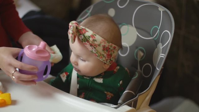 the little girl is drinking from the trough