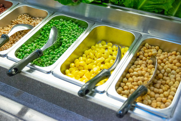 Freshly cut vegetables are lined up in a tray for sale as a vegetable salad in the supermarket.