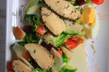 Lettuce salad with chicken fillets, eggs, and sauce