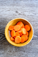 dried carrots in bowl on wooden table