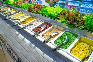 Freshly cut vegetables are lined up in a tray for sale as a vegetable salad in the supermarket.