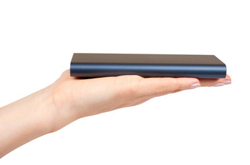 Hand with dark blue power bank for charging mobile devices, external battery.
