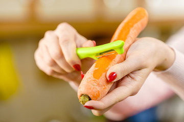 Woman peeling carrot vegetable