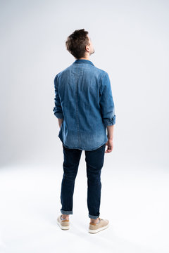 back view of a casual man standing on white background.