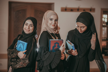 Three muslim girls reading Quran in mosque