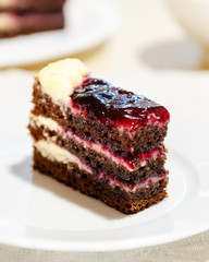 close-up of a slice of chocolate cake with cream and jam
