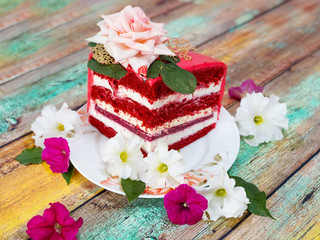 Obraz na płótnie Canvas A piece of festive red cake on a wooden background