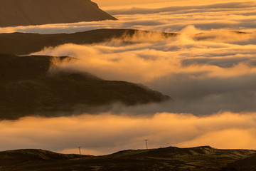  Dreamy misty landscape above the sea of clouds, mountains at sunset in Iceland