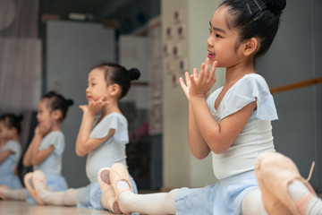 Choreographed dance by a group of young pretty Chinese ballerinas practicing during class at the...
