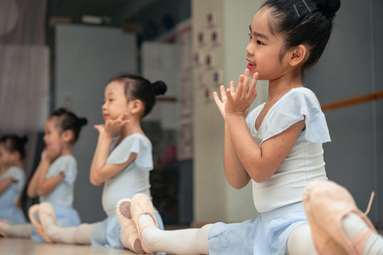 Choreographed dance by a group of young pretty Chinese ballerinas practicing during class at the classical ballet school