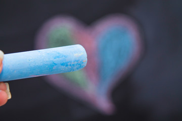 Drawing of heart with blue crayon on blackboard