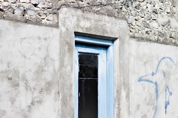 Blue wooden door with a black glass of a maldivian house (Ari Atoll, Maldives)