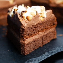 Delicious chocolate cake on table oN black  background, closeup