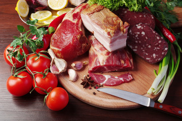 Meat products and vegetables. Ham and sausage, lemon, tomatoes, peppers, lettuce and parsley