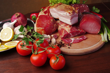 Meat products and vegetables. Ham and sausage, lemon, tomatoes, peppers, lettuce and parsley