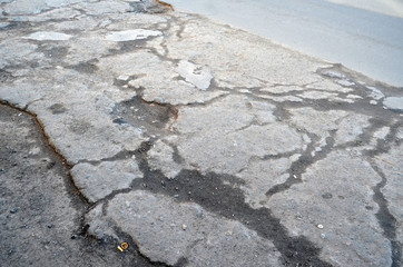 Poor condition of the road surface. Winter season. Hole in the asphalt, risk of movement by car, bad asphalt, dangerous road, potholes in asphalt.  Kiev,Ukraine