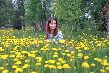 Naklejka na ściany i meble girl resting on a sunny day in meadow of yellow dandelions