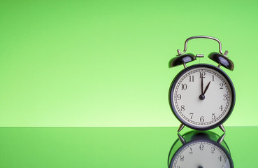 Alarm Clock on green background with selective focus. Copy space  and business concept