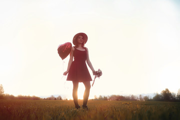 A girl in a hat on a walk in the park. A girl with a basket walks in autumn. A girl is walking along the road at sunset.