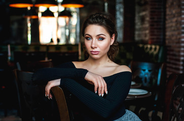 portrait of a beautiful girl, a girl sits on a chair in a cafe