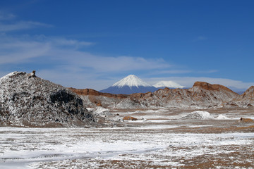 Fototapeta na wymiar Valle de la Luna (Valley of the Moon) with the snowy Licancabur volcano in the background, the white in the foreground is salt, Atacama Desert, Chile