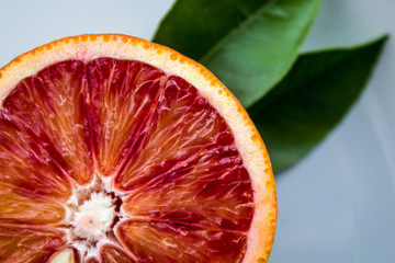 macro cut of red blood orange with leaves. copy space