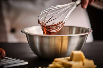 Chef preparing melted chocolate in a mixing bowl