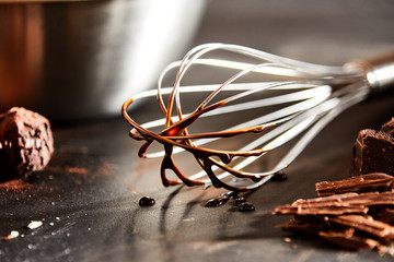 Melted chocolate coating an old metal whisk