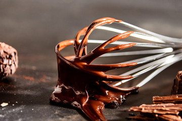 Thick melted chocolate coating an old metal whisk