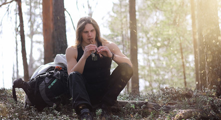 A musician with a tool in nature. A man is playing a flute in a pine forest. The music of the...