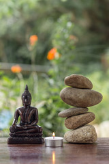 buddha with balanced zed stones and a candle