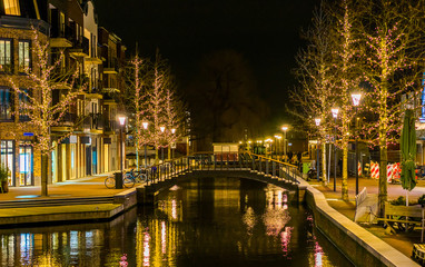 canal bridge in the center of Alphen aan den Rijn, The netherlands, decorated trees with lights,...
