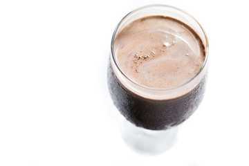 Top view of a sweating gglass of milkshake chocolate in a white background. Deliciuos cold chocolate drink.