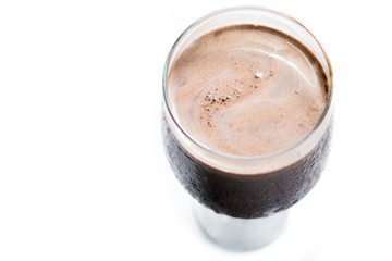 Top view of a sweating gglass of milkshake chocolate in a white background. Deliciuos cold chocolate drink.