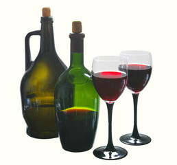 Two glasses of red wine and two bottles on white. Isolated on white