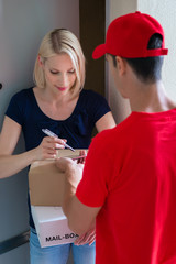 Woman signing on device to delivery parcel
