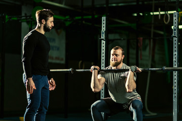 Naklejka premium Man with heavyweight barbell in the dark gym.