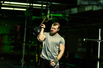 Man with heavyweight in the dark gym.