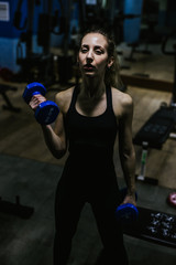Fototapeta na wymiar Young girl trains hard in the gym