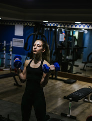 Fototapeta na wymiar Young girl trains hard in the gym