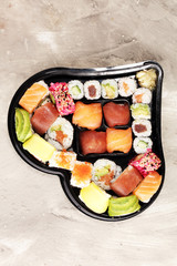 close up of sashimi sushi set with chopsticks and soy - sushi roll with salmon and sushi roll with...