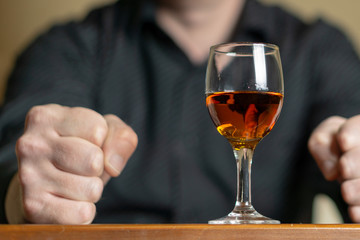 Brandy glass and clenched fists of men