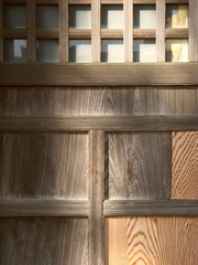 早春の木洩れ日のあたる祠の拝殿の戸