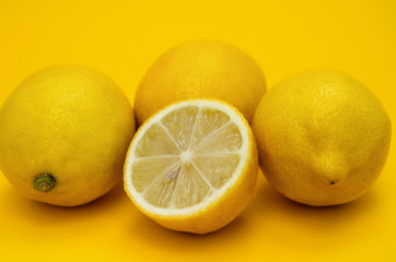 Fresh lemons on yellow background