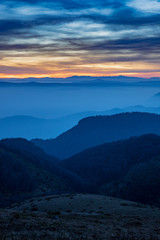 Fototapeta na wymiar Layers of Mountain Ridges with fog at sunset