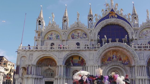 Venice, Italy Saint Mark square with masks and Basilica view during carnival. Day view of Basilica di San Marco facade at Piazza San Marko, during Venetian carnival celebrations.